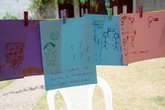 Pink and blue papers are strung up on a washing line with stick figures and handwritten text